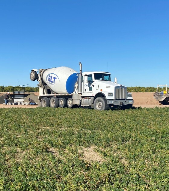 Mixer pouring headgate in field on ditch 3 guys truck 02.07.23
